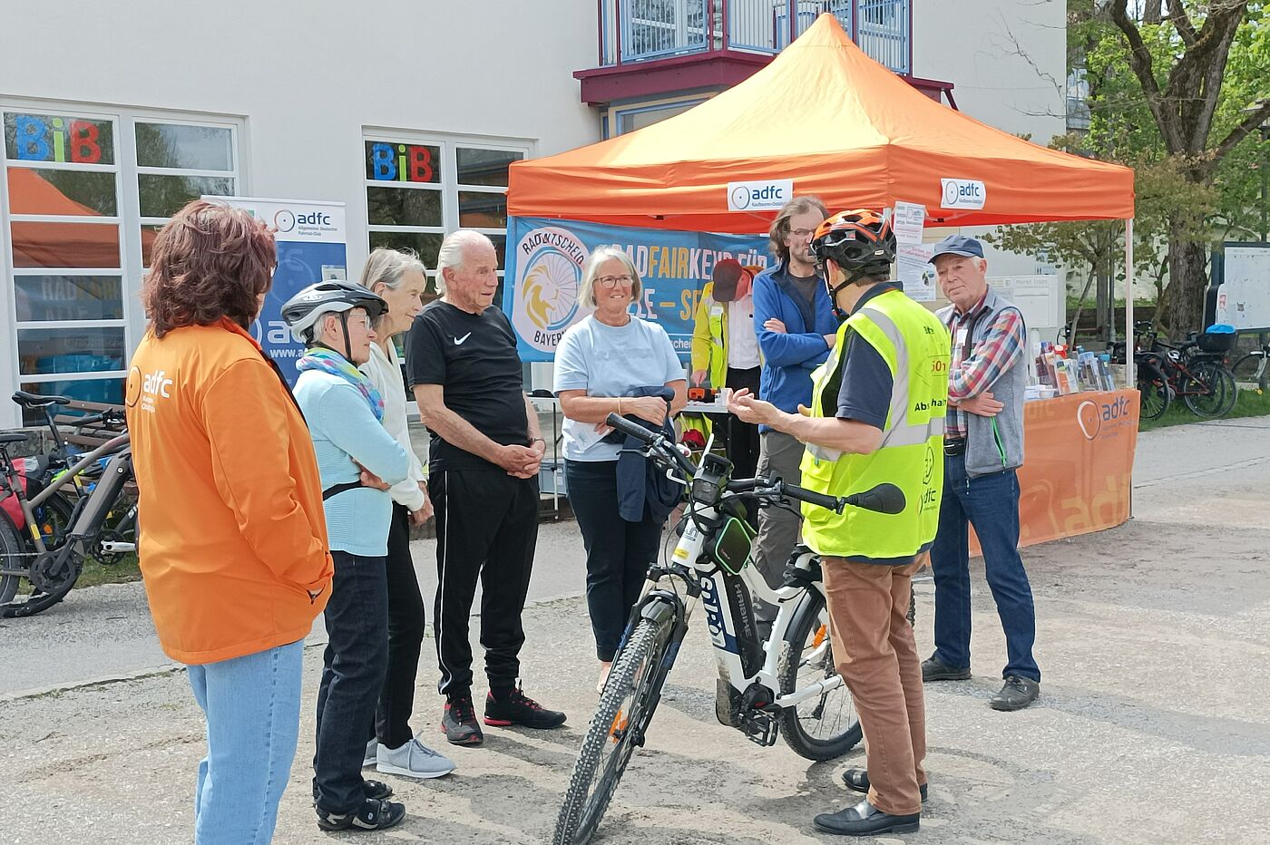 Fahrtechnik Erwachsene stehen um ein Rad
