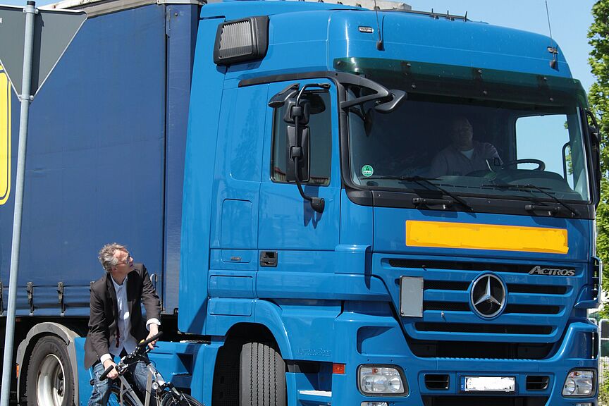 Fahrradfahrer neben LWK beim Abbiegen Fahrradfahrer neben LWK beim Abbiegen